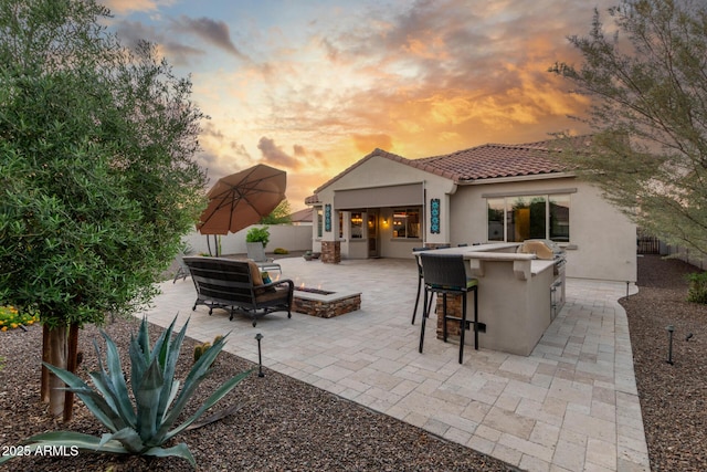 patio terrace at dusk featuring fence, a grill, and an outdoor hangout area