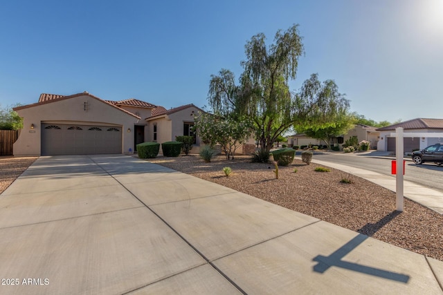 mediterranean / spanish home featuring a garage, driveway, stucco siding, and a tile roof