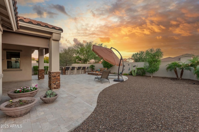 patio terrace at dusk with a fenced backyard