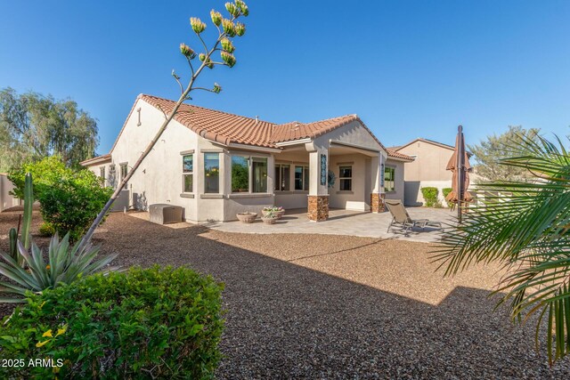 back of house with stucco siding, a patio, and a tiled roof