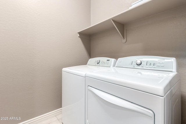 laundry area with independent washer and dryer and light tile patterned floors