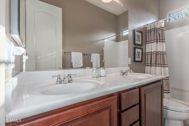 full bathroom with toilet, double vanity, a textured wall, and shower / bath combo