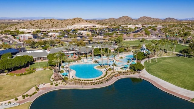 aerial view of property's location with nearby suburban area, a water and mountain view, and a pool