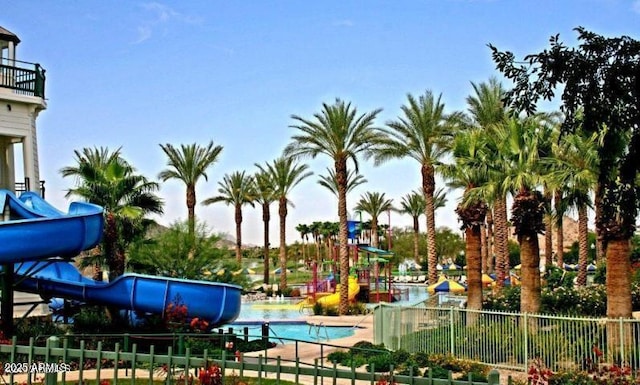 community pool with a water slide and fence