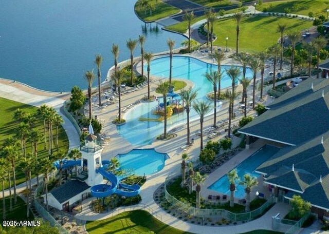 drone / aerial view of a pool area and a large body of water
