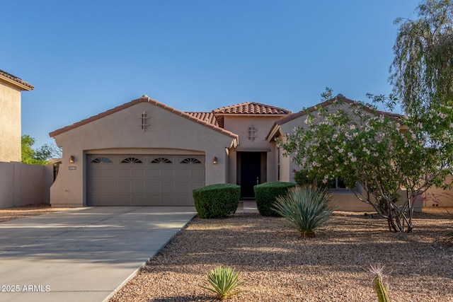 mediterranean / spanish home featuring stucco siding, a garage, driveway, and a tile roof