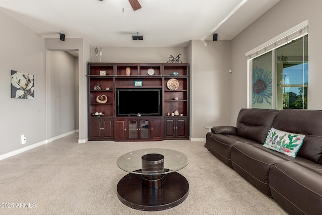 living room featuring ceiling fan, baseboards, and light colored carpet