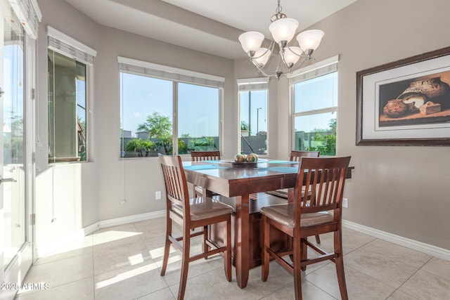 dining space featuring a chandelier, light tile patterned flooring, and baseboards