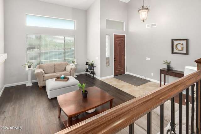 living room with dark wood-type flooring and a high ceiling