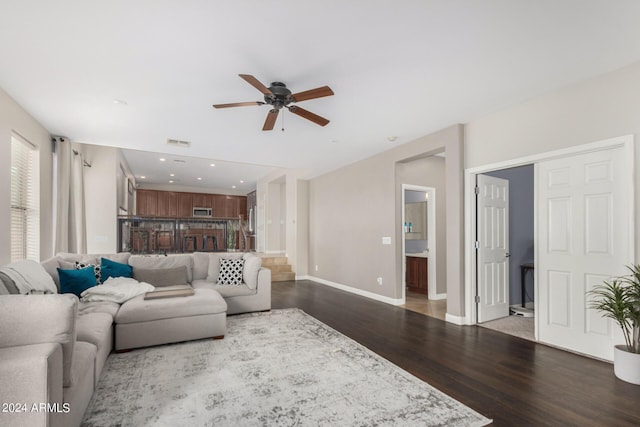 living room with dark wood-type flooring and ceiling fan