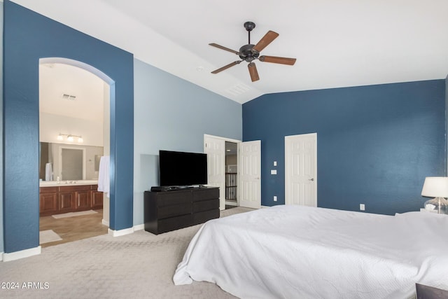 carpeted bedroom featuring lofted ceiling, connected bathroom, and ceiling fan