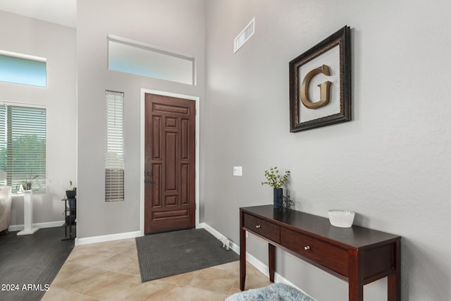 foyer entrance with light tile patterned floors and a high ceiling