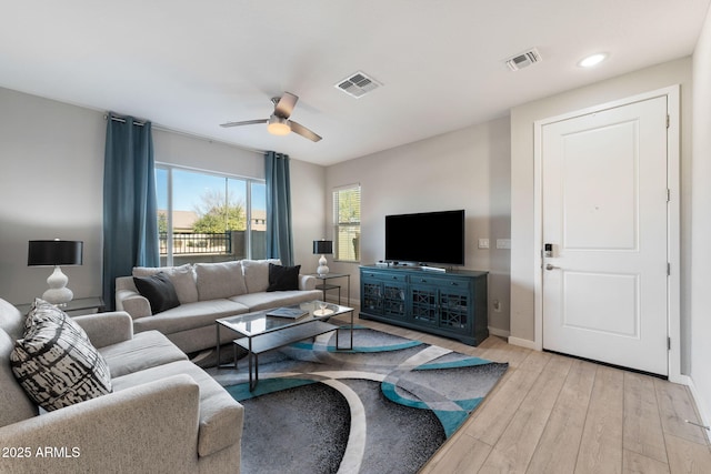 living room featuring ceiling fan and light hardwood / wood-style flooring