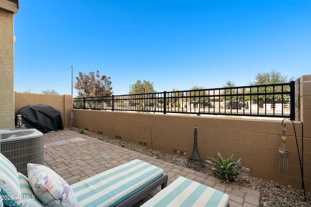 view of patio featuring a wall unit AC, central AC unit, and grilling area