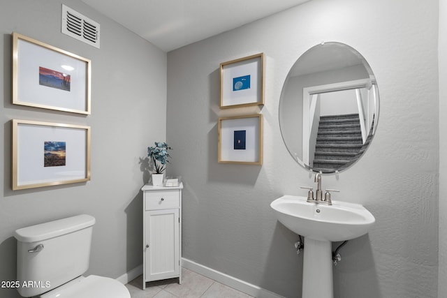 bathroom with sink, toilet, and tile patterned flooring