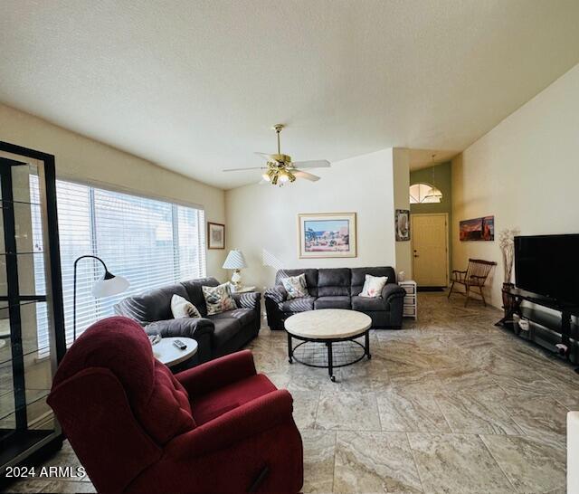 living room with a ceiling fan and a textured ceiling