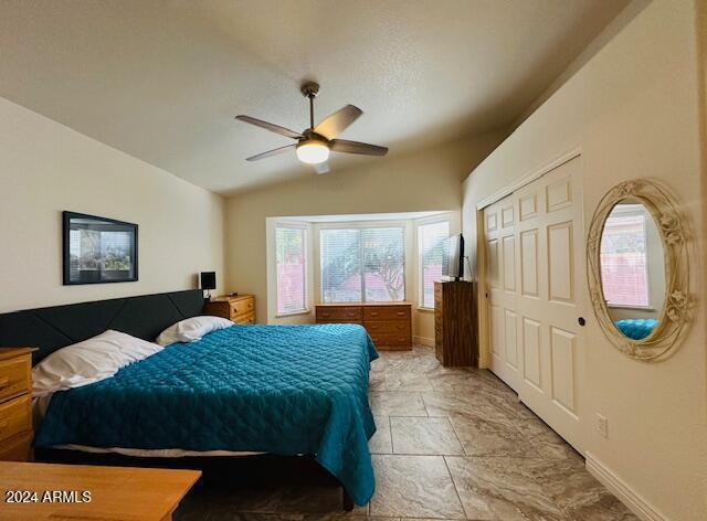 bedroom with a closet, vaulted ceiling, and ceiling fan