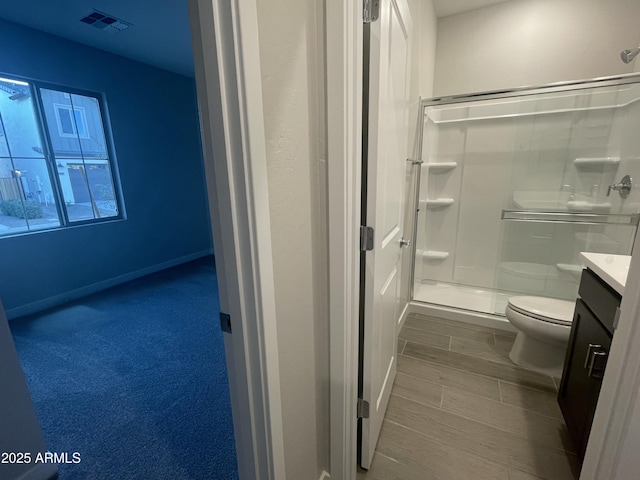 bathroom featuring vanity, toilet, and an enclosed shower