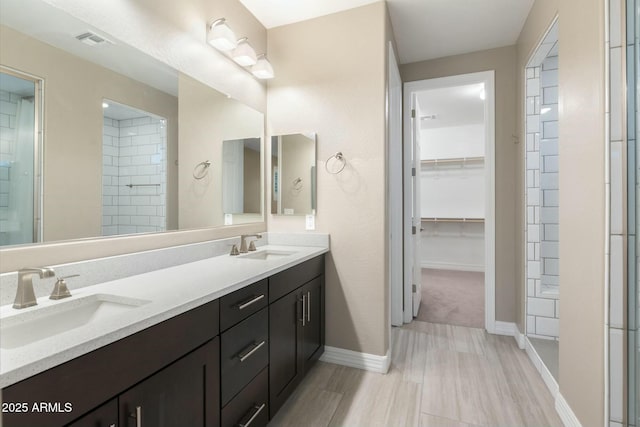 bathroom featuring vanity, walk in shower, and wood-type flooring