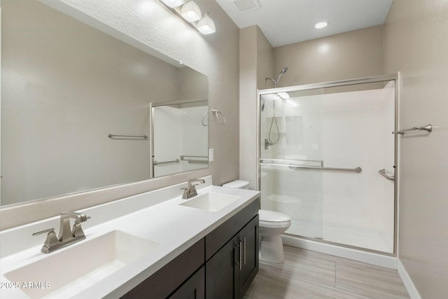 bathroom with vanity, an enclosed shower, and toilet