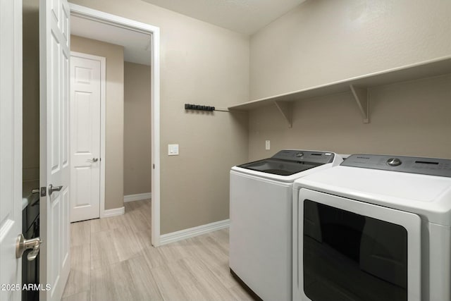 laundry room with washer and dryer and light wood-type flooring