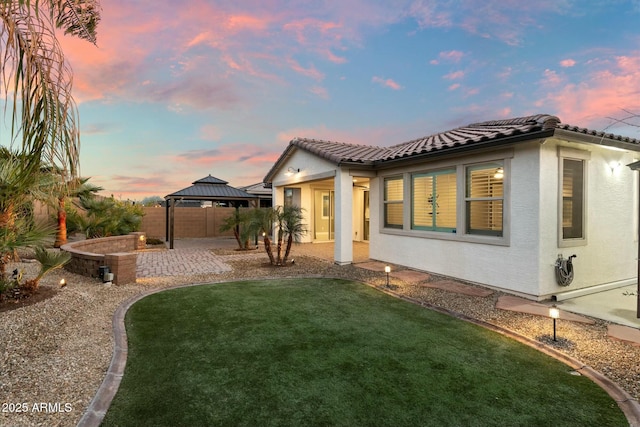 exterior space featuring a patio area, a lawn, and a gazebo