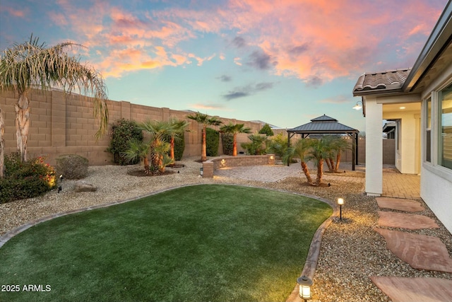 yard at dusk featuring a gazebo