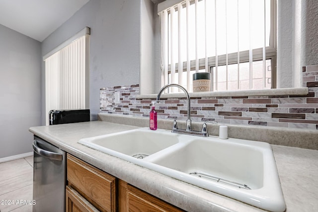 kitchen featuring dishwasher, sink, and tasteful backsplash