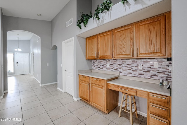 kitchen with backsplash, light tile patterned flooring, and pendant lighting