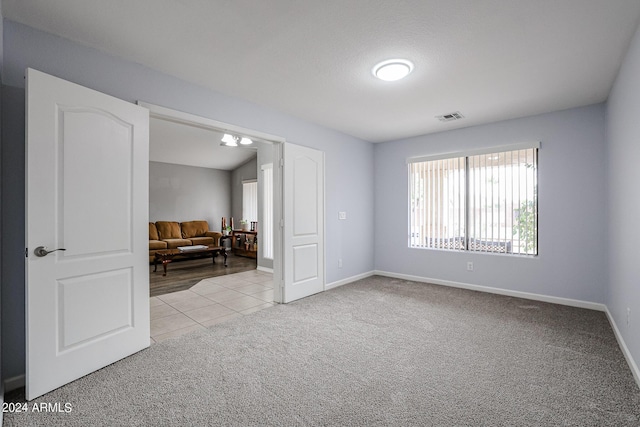 carpeted empty room with lofted ceiling