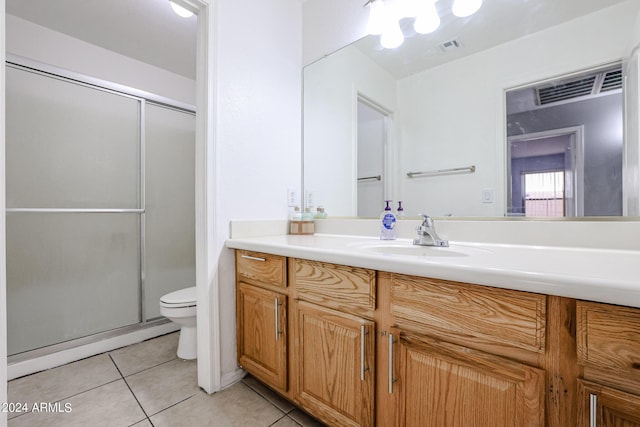 bathroom with tile patterned flooring, vanity, toilet, and walk in shower