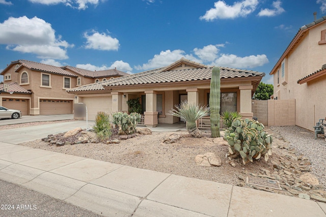 mediterranean / spanish-style home featuring a porch and a garage