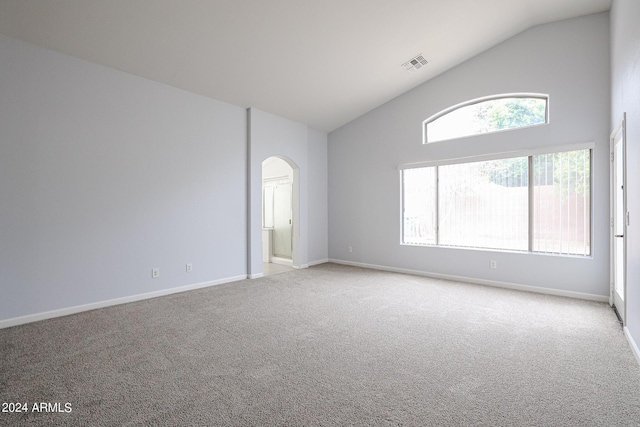 unfurnished room with light colored carpet and lofted ceiling