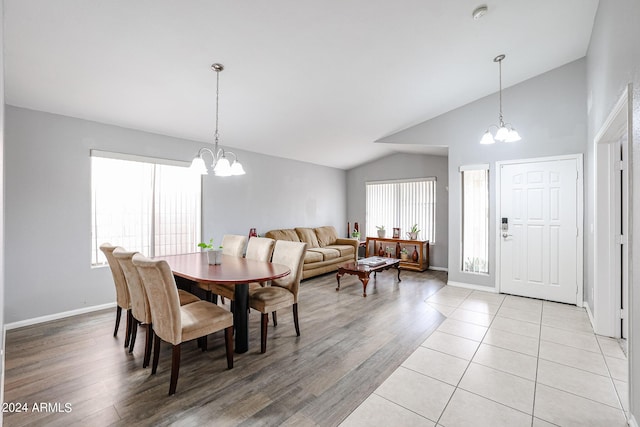 dining area featuring lofted ceiling, light hardwood / wood-style flooring, and a chandelier