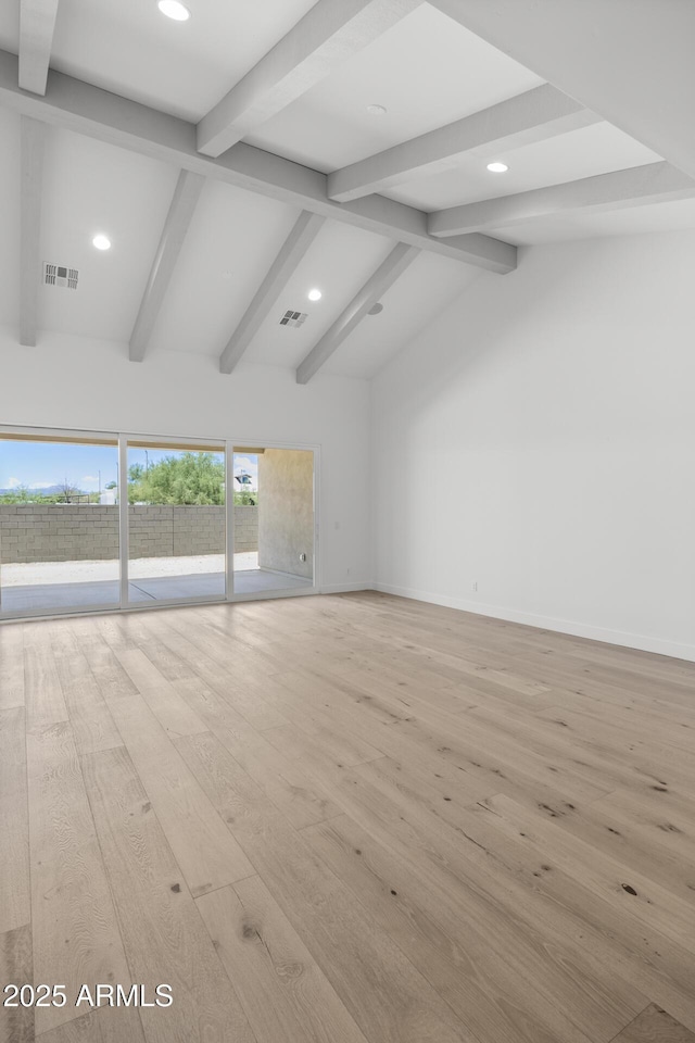 unfurnished living room with light wood-type flooring, baseboards, lofted ceiling with beams, and visible vents