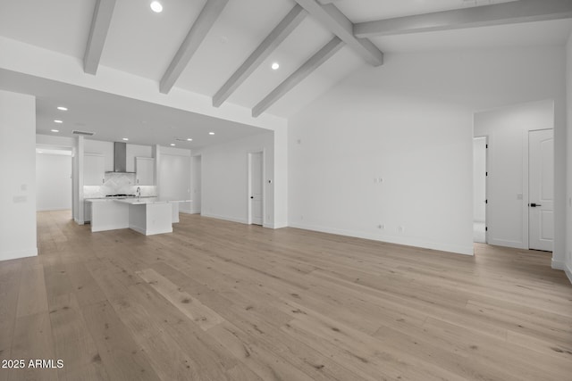 unfurnished living room with vaulted ceiling with beams, light wood finished floors, baseboards, and recessed lighting