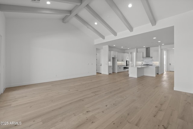 unfurnished living room with light wood-type flooring, baseboards, beamed ceiling, and recessed lighting