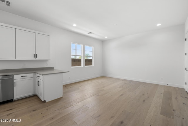 interior space with visible vents, open floor plan, white cabinetry, light wood-type flooring, and dishwasher