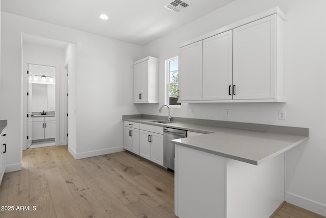 kitchen featuring visible vents, dishwasher, a peninsula, light wood-style floors, and white cabinetry