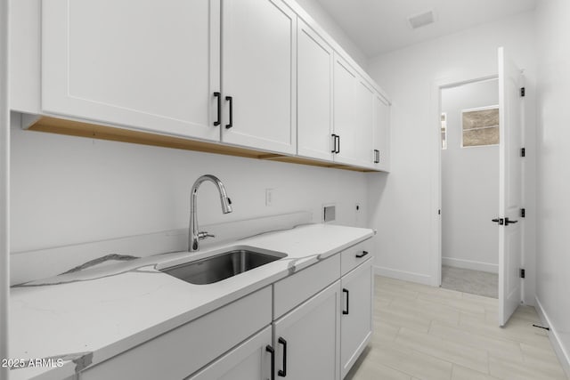 laundry area with washer hookup, cabinet space, hookup for an electric dryer, a sink, and baseboards