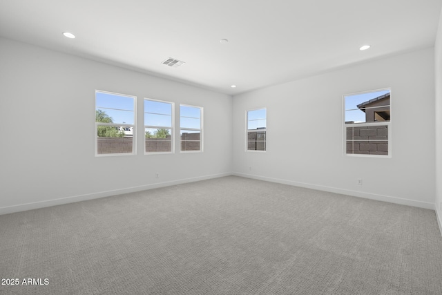 spare room with recessed lighting, carpet flooring, visible vents, and baseboards