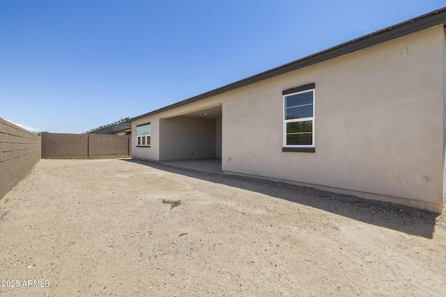 exterior space with a fenced backyard and stucco siding