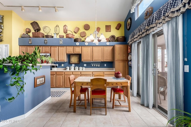 kitchen featuring light tile patterned floors, a high ceiling, rail lighting, and light countertops