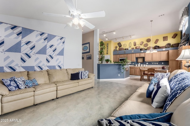 living area featuring rail lighting, light tile patterned floors, and a ceiling fan