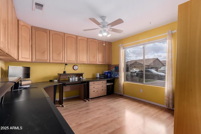 office featuring visible vents, light wood-style flooring, built in desk, baseboards, and ceiling fan