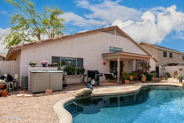 rear view of property with stucco siding, fence, a fenced in pool, and a patio area