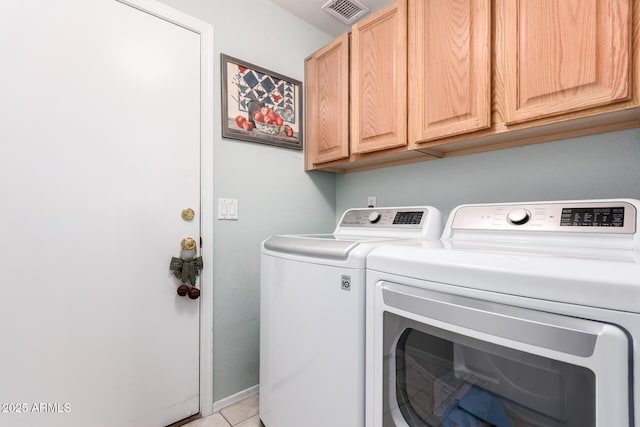 washroom featuring cabinet space, light tile patterned floors, washing machine and dryer, and visible vents