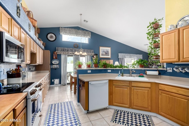 kitchen with a chandelier, light countertops, appliances with stainless steel finishes, a peninsula, and a sink