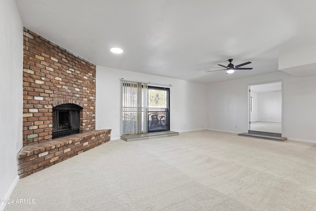 unfurnished living room with ceiling fan, carpet floors, and a brick fireplace