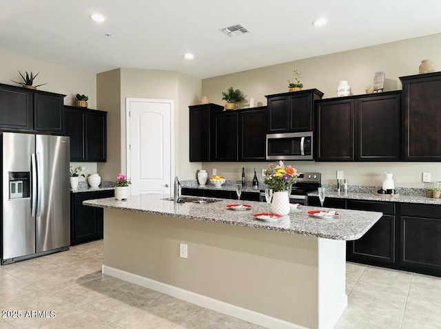 1255 N Arizona Ave Unit 1235, Chandler, AZ 85225 - kitchen with stainless steel appliances, light stone countertops, a kitchen island with sink, light tile patterned floors, and recessed lighting
